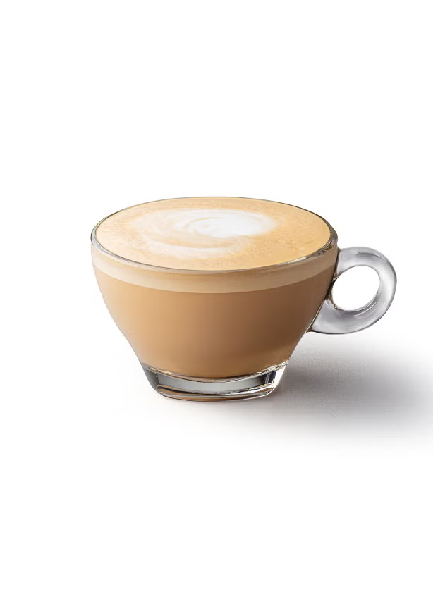 Un flat white într-o cană de sticlă